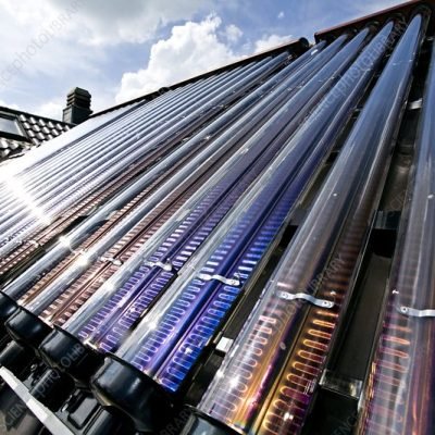 Vacuum tube solar panel fitted to a roof. This type of solar panel consists of a row of tubes that are heated by the sun. Inside each tube is a second tube sealed within a vacuum. The collector fluid, which absorbs the heat from the sun, flows through the inner tubes. This system is more efficient than conventional flat panels in bad weather conditions. Photographed in Aywaille, Belgium.